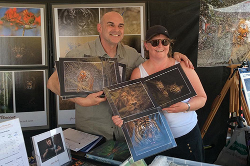 lady holding wildlife prints she has just purchased from photographer Ashley Vincent