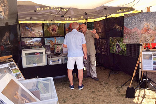 wildlife photographer Ashley Vincent talking to a customer at an outdoor event