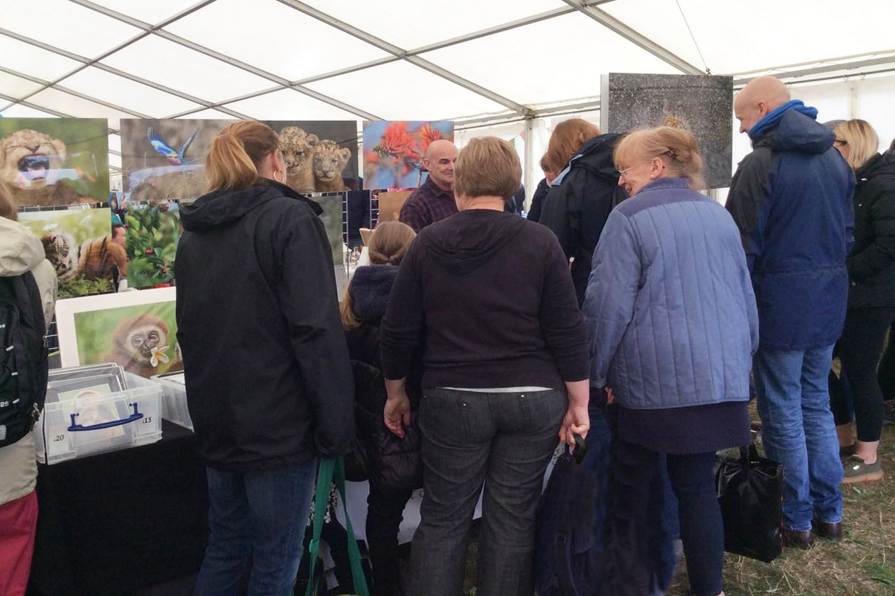 crowd of people looking at the event stand of wildlife photographer Ashley Vincent