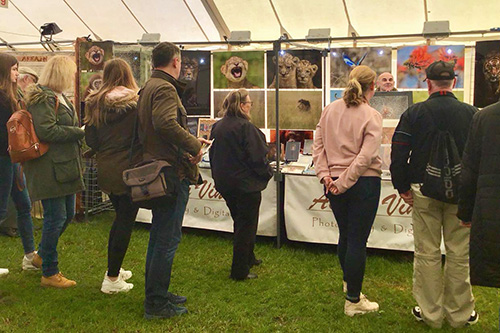 people engaging with Ashley Vincent at his picture display stand at Morden Park