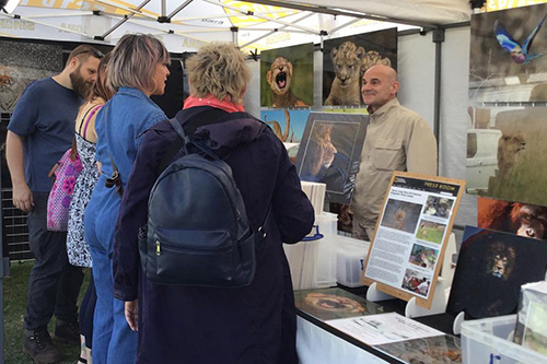 customers engaging with Ashley Vincent at his picture display gazebo at the Thai Festival in Milton Keynes