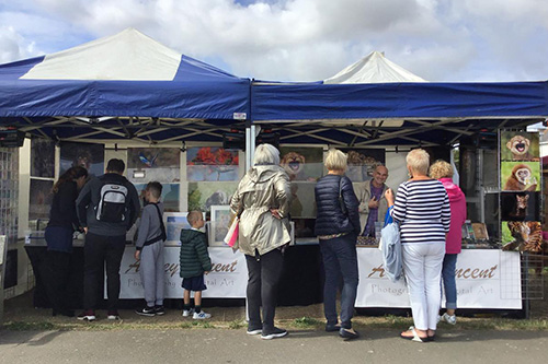 customers engaging with Ashley Vincent at his picture display gazebo at the food and drink festival in Deal