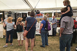 people engaging with Ashley Vincent at his picture display stand at the Royal County of Berkshire Show