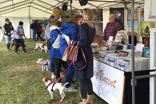 people engaging with Ashley Vincent at his picture display stand at the All About Dog Show in Ipswich