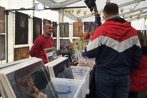 customers engaging with Ashley Vincent at his picture display gazebo at the Knebworth Christmas Fair