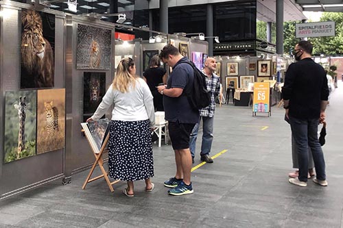 customers engaging with wildlife photographer ashley vincent at his stand at the Spitalfields arts market in london