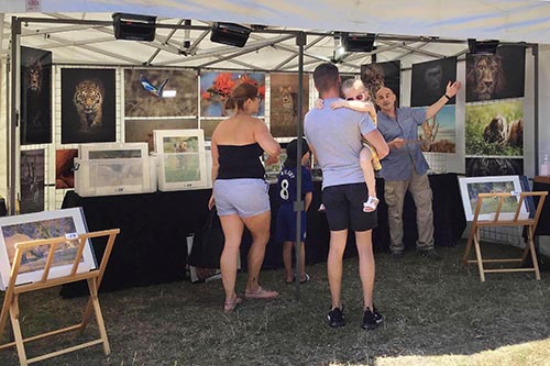 customers engaging with wildlife photographer ashley vincent at his stand at the Hythe summer market
