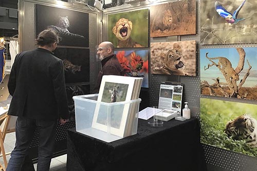 customer engaging with wildlife photographer ashley vincent at his stand at the Spitalfields arts market in london